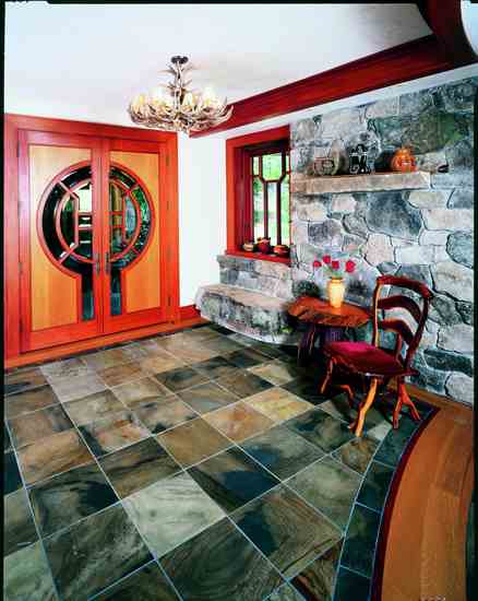 The entry door plays on the imagery of the traditional keyhole and includes a moon/sun window and references to the four directions and seasons. A two-ton boulder slab was set into the entry wall to provide a bench for removing shoes upon entering.